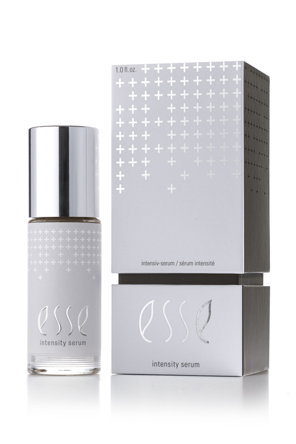 A bottle of Esse Intensity Serum with a silver cap is shown beside its matching silver and white box, both displaying minimalist plus sign patterns and modern typography.