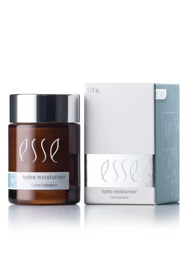 A 1.7 fl oz jar of Esse Hydro Moisturiser featuring a brown and silver lid is displayed alongside its matching box. The sleek packaging boasts white, silver, and blue accents. The text on both the jar and the box describes the product as a hydrating cream.